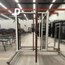 Handcrafted white iron pivot door frame showing slim metal structure and modern glass panel layout