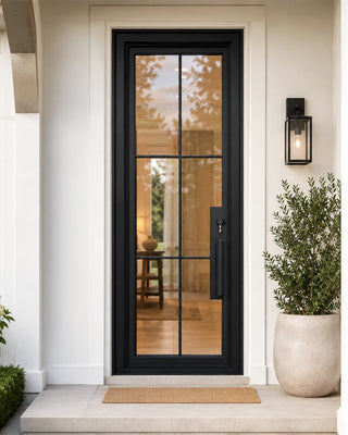 Modern black door with glass panels on a white house exterior.
